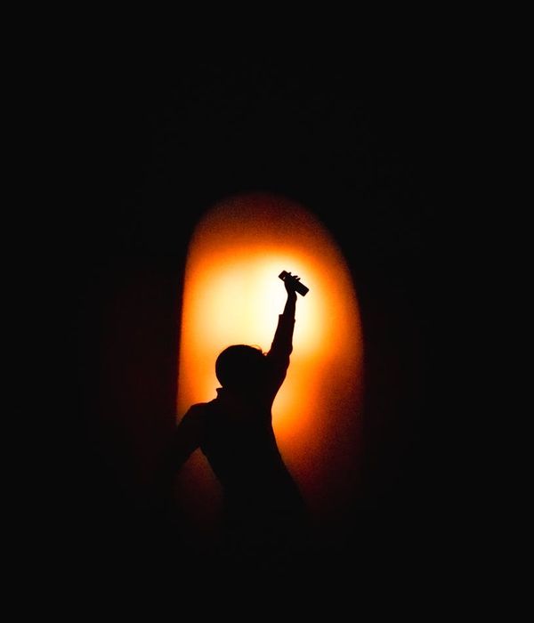 Woman in a dynamic pose, full of energy against a dark background.
